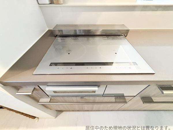 丹生中古のキッチン|シンプルなデザインのIHクッキングヒーターが設置されています。作業スペースがゆとりのある仕様です。お手入れもしやすい仕様となっています。すっきりとまとまったキッチンです。