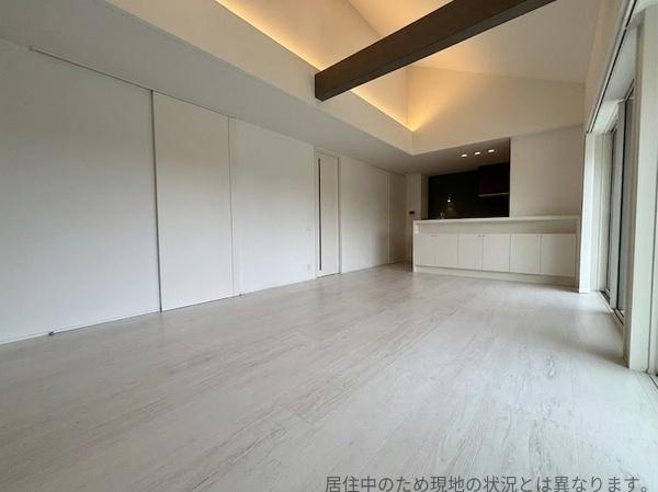 丹生中古の居間・リビング|天井まで続く開放感のある空間が魅力です。スタイリッシュな照明と白を基調とした内装が印象的です。リビングからキッチンまで広々とした間取りとなっております。