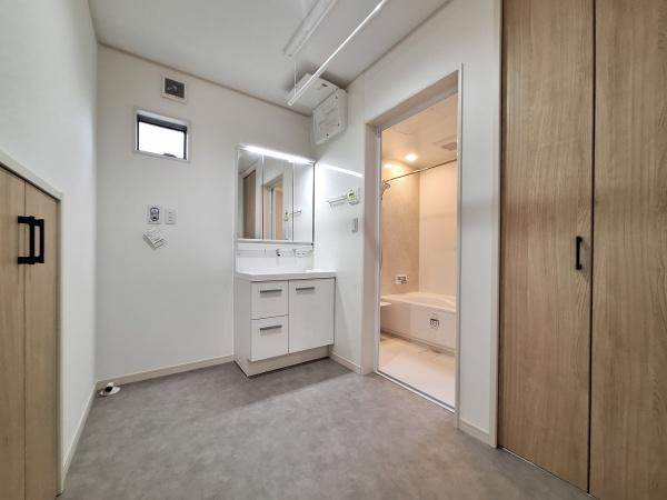 森1号新築建売住宅の独立洗面台|明るい照明が特徴の洗面台は清潔感があります。収納スペースが充実しており片付けがしやすい仕様です。バスルームへのアクセスもスムーズなレイアウトとなっています。