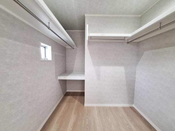 森1号新築建売住宅の収納|広々とした空間が特徴の収納です。ハンガーパイプや棚が設けられており使いやすさが感じられます。窓からの自然光も取り入れられ収納内の明るさが確保されています。シンプルな内装で整理整頓がしやすい仕様です。