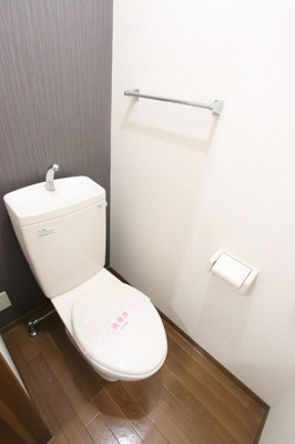 明るい壁紙のトイレです