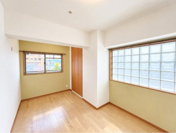 グラン コープ枚方 香里ケ丘　中古 マンションの洋室|大きなガラスブロック窓が印象的な、個性あふれる洋室。やさしい色合いの壁と木目の床が温もりを演出。2面採光の明るさと便利な収納を備え、子ども部屋や書斎にもぴったりの空間です。