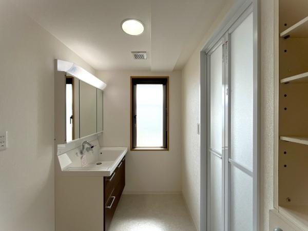 グラン コープ枚方 香里ケ丘　中古 マンションの独立洗面台|洗面所も大きな窓で明るい空間になっています。