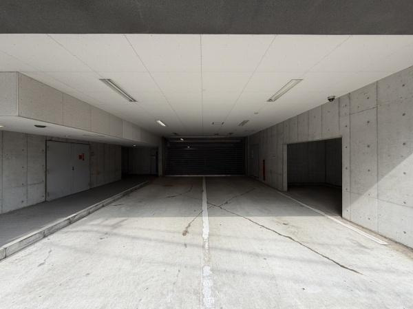 アリュール鶴見寺谷の駐車場|屋根付きの駐車場なので雨の日でも安心してご利用いただけます。コンクリートの床面が整備されており駐車しやすい作りです。照明設備も整っているため夜間でも明るい環境です。清潔感のある空間となっています。