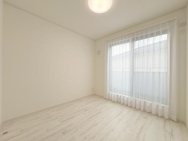横浜市旭区川井本町の中古一戸建の洋室|大きな窓から自然光が差し込む明るい洋室です。白を基調とした壁と床が空間をすっきりと見せています。シンプルなデザインでインテリアも合わせやすい一部屋です。天井照明付きで夜も明るさを保てます。