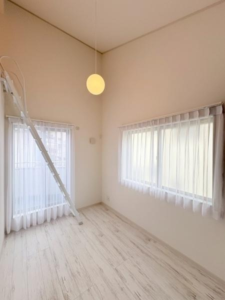 横浜市旭区川井本町の中古一戸建の洋室|大きな窓から光が入り明るい印象の洋室です。天井が高く開放感を感じられます。白を基調とした床と壁で空間がすっきりしています。ロフトへの梯子が設置されています。シンプルな照明もポイントです。
