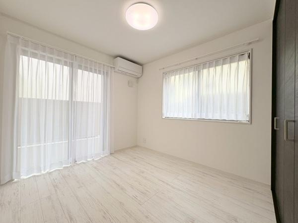 横浜市旭区川井本町の中古一戸建の洋室|約5.1帖。二面採光で室内が明るく開放的な印象です。白を基調とした床や壁が清潔感を演出しています。エアコンが設置されているので快適にお過ごしいただけます。大きな窓で換気もしやすく過ごしやすい空間です。