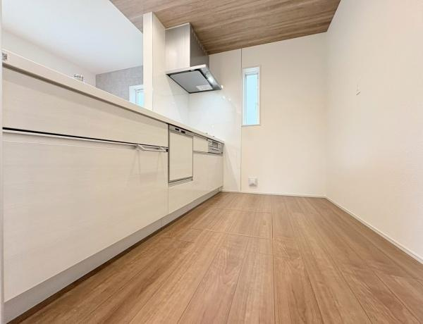 大和市上和田の新築一戸建のキッチン|清潔感のあるホワイトカラーのキッチンは収納スペースもしっかり確保されています。広い作業台で調理がはかどります。ガスコンロと換気扇が設置されており使いやすさに配慮されたレイアウトです。