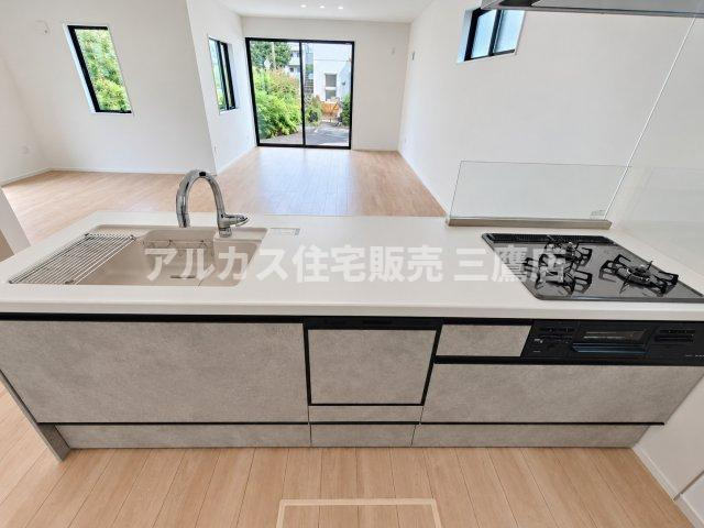 西東京市南町2丁目　西武新宿線　田無駅　新築戸建のキッチン|グレーのモダンスタイルな対面キッチン。食洗機や広々としたシンク、タッチレス調の水栓を備え、機能性とデザイン性を両立しています。