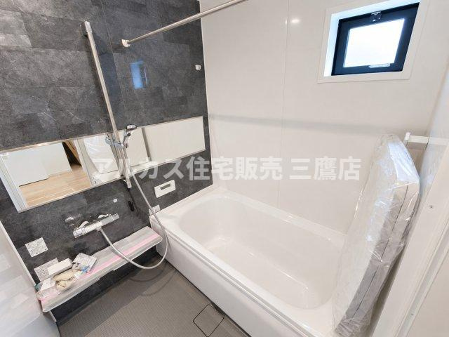 西東京市南町2丁目　西武新宿線　田無駅　新築戸建の浴室|シックなグレーのアクセントパネルが上質な空間を演出するバスルーム。小窓付きで換気しやすく、毎日のバスタイムを快適に過ごせます。