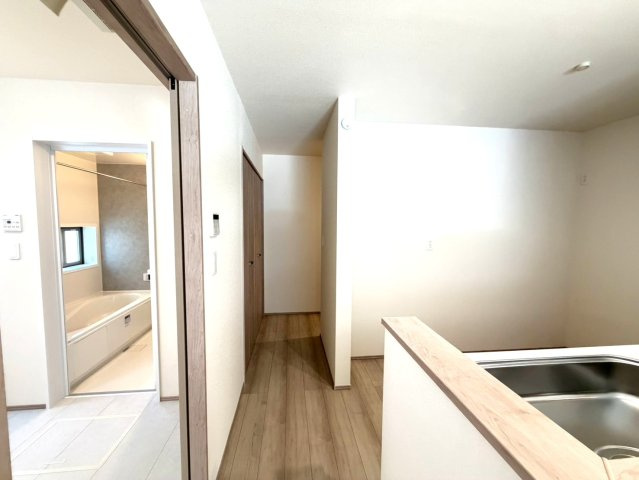 静岡市葵区田町７期　新築戸建　全７棟　F号棟の内装|キッチン裏にはパントリーを配置し、食品や日用品のストックをまとめて収納。さらに左奥にも収納を備え、生活感をすっきり隠せる間取りです。