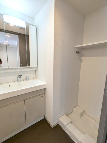 エスレジデンス新御徒町chiaroの洗面所|トイレと独立した脱衣洗面室、三面鏡付ハンドシャワー付独立洗面台、洗濯機置場は排水口のお手入れをしやすく中央手前に配置し足高の防水パンです