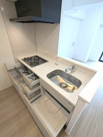 エスレジデンス新御徒町chiaroの設備|グリル付ガス3口システムカウンターキッチン、瀟洒でお手入れ楽なガラストップコンロ、収納は奥まで整頓しやすい手前にスライド式