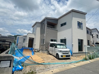 【外観】 | 東広島市西条町田口　最終1棟 | 白とグレーを基調としたスタイリッシュな外観。南東向きの設計により陽当りも期待できます。前面には並列や複数台の駐車に対応可能なゆとりあるスペースが確保されており、ミニバン等大型車も配置しやすい形状です。