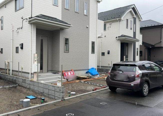 【前面道路含む現地写真】 | 幅約５．１ｍのゆとりある西側公道に面した現地写真です。前面道路は交通量が少なめで静かな住環境となっており、車のすれ違いや庫入れも安心しておこなっていただけます。ぜひ現地でお確かめください。