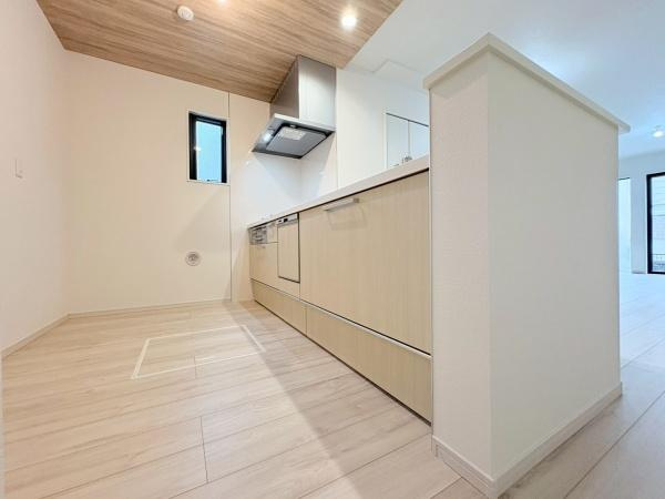 大和市上和田の新築一戸建のキッチン|木目調の天井と明るい床材が調和したキッチンです。自然光が差し込む開放的な空間です。対面式の設計でリビングスペースの家族とコミュニケーションしやすいです。
