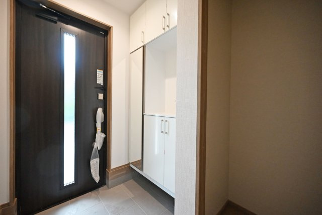 ハートフルタウン荻野1丁目新築一戸建て│3LDK+並列駐車2台可（制限あり）の玄関|1階玄関をホール側から撮影した内観写真です。 シンプルな玄関扉にシューズボックス、小窓を配置したオーソドックスな玄関です。