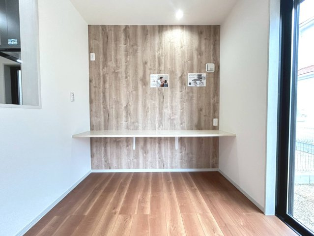 新築戸建　江南市宮後町砂場東　全10区画分譲の居間・リビング|リビングのアクセントクロスの前にはデスクコーナーがございます。お子様の学習スペースや、リモート業務、アイロンがけ等の家事コーナーとしてもお使いいただけます。