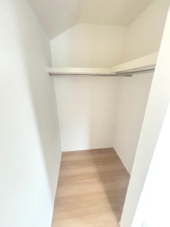 【収納】 | 佐伯区美鈴が丘西4丁目（全1棟） | 7帖の主寝室に直結した大容量のウォークインクローゼットです。ハンガーパイプと枕棚がL字型に配置され、衣類から季節家電、スーツケースまでまとめて管理可能。お部屋を広く使うための心強い収納スペースです。