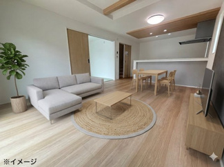 【居間・リビング】 | 佐伯区美鈴が丘西4丁目（全1棟） | 16帖のLDKは、グレーのアクセントクロスが落ち着いた雰囲気を演出。折り上げ天井には木目調のデザインが施され、空間に奥行きと開放感を与えます。隣接する和洋室の引き戸を開放すれば、広々と活用可能です。