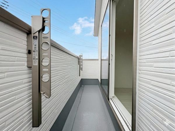 横浜市旭区金が谷２丁目の新築一戸建のバルコニー|すっきりとしたデザインのバルコニーが特徴です。壁面は清潔感のあるホワイト調で明るい印象を与えます。屋外の空気を取り込みやすい開放感のある空間です。物干し金物も設置されています。