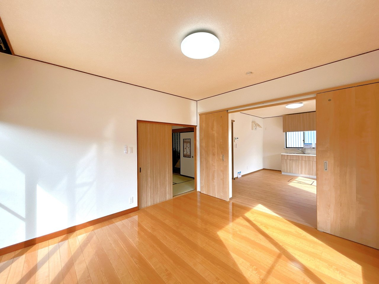 桜川市青柳　中古戸建の居間・リビング|【リフォーム完成・即入居可】リビングの写真です。床ワックスがけ、クロス張替、照明交換等行いました。北側のキッチン・ダイニングスペースと仕切ることもでき、建具を開けることでつなげて使うこともできます。