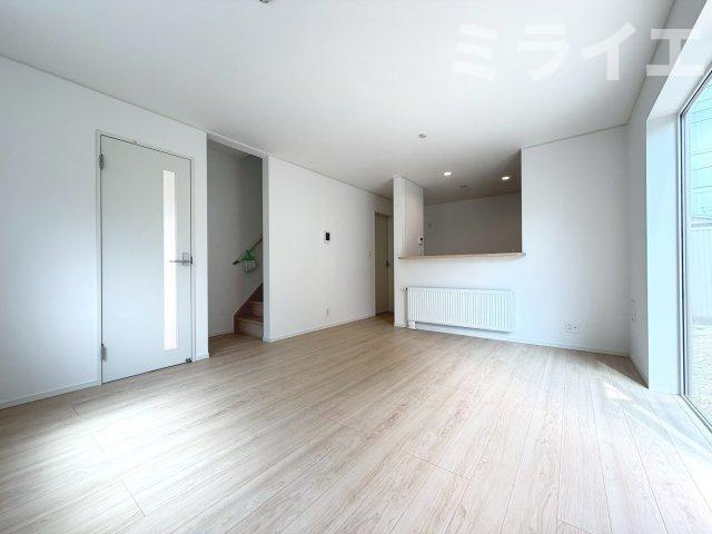 【新築戸建】札幌市東区北51条東2丁目2棟の居間・リビング|リビング全体を見渡せる対面キッチンを採用。壁・床・建具は白を基調とした内装で、明るく開放感のある空間を演出しています。