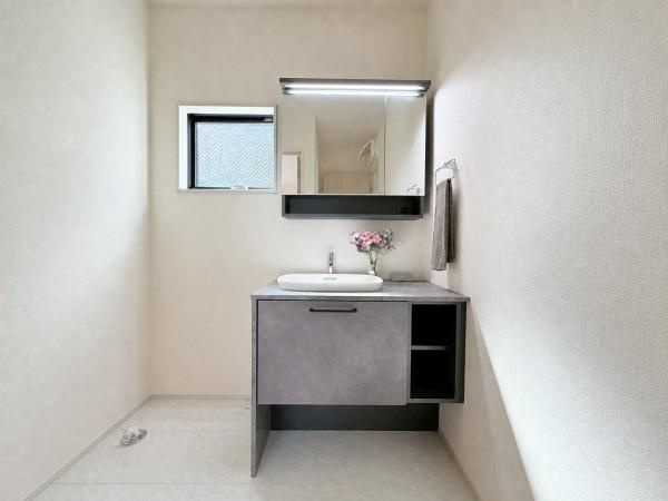大和市福田の新築一戸建の独立洗面台|鏡付きの洗面台と収納が設けられています。グレーを基調としたシンプルなデザインです。洗濯機置き場もあり使い勝手が良い印象です。
