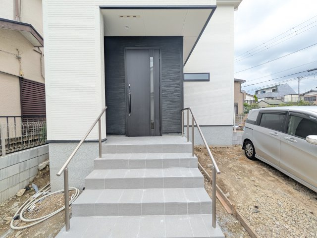 取手市新取手　2丁目　01期　新築戸建ての玄関|玄関ドアはカードキーで開閉も楽々♪
スマホでの開錠と施錠も可能です！
玄関上部には人感センサー付きのダウンライトがあるので、夜間の帰宅時に自動で点灯してくれます♪
防犯対策面にも一役買ってくれます！