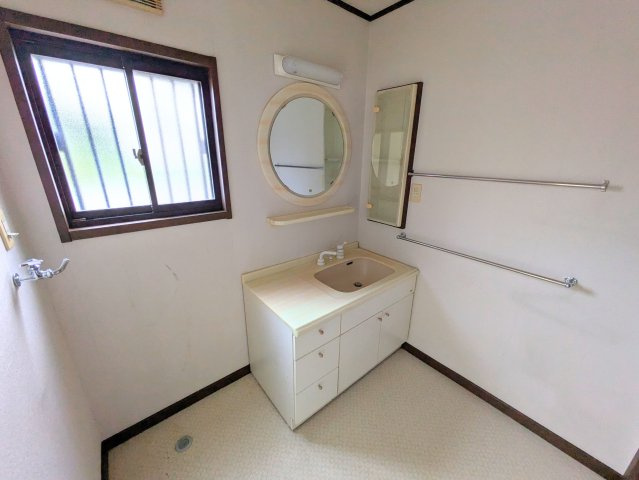 白水台1丁目戸建の独立洗面台|丸い鏡が特徴的な独立洗面台です。小窓があり、明るい空間で朝の身支度をスムーズに行えます。