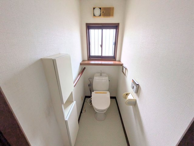 白水台1丁目戸建のトイレ|窓と棚付きの収納を備えたトイレです。手すりが付いているため、どの世代でも使いやすい設計です。