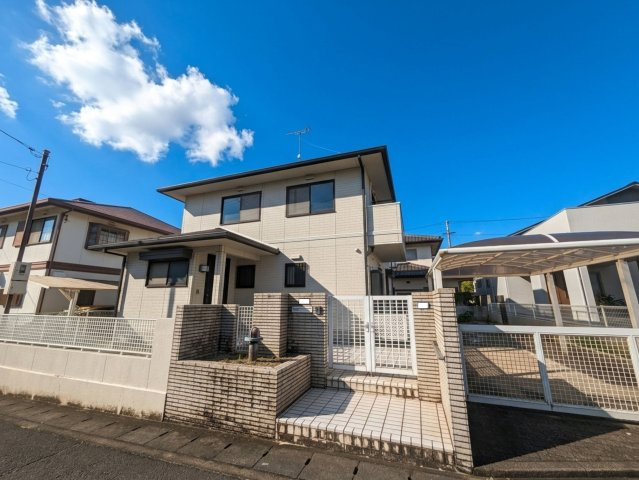 白水台1丁目戸建の外観|青空に映える明るい外壁の一戸建てです。カーポート付きの駐車場や門扉があり、プライバシーにも配慮。