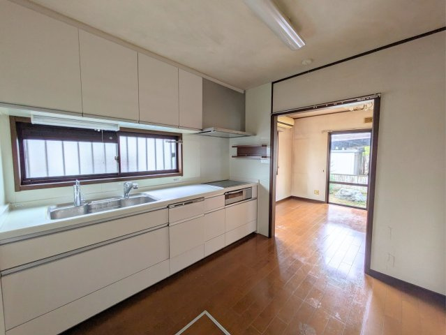 白水台1丁目戸建のキッチン|上下に豊富な収納を備えたシステムキッチンです。窓からの自然光を感じながら、快適に調理を楽しめます。