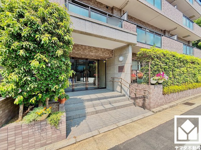 ファミール甲子園浦風町のエントランス|緑に囲まれたエントランスが、都会の喧騒を忘れさせる。自然と調和する、美しい迎賓空間。
