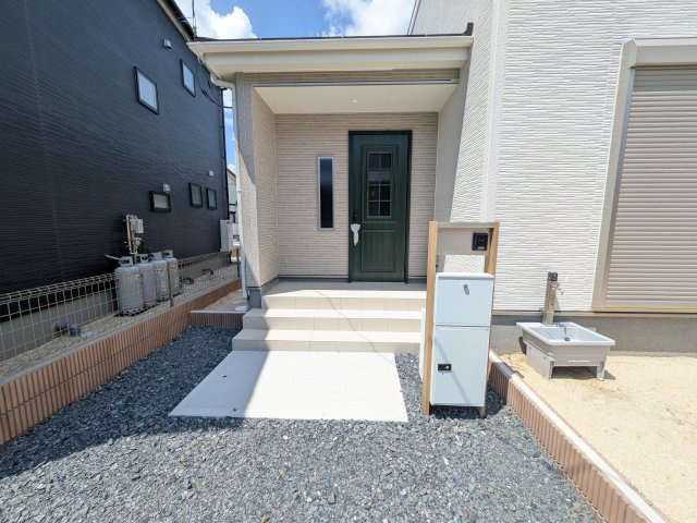 第1　常総市収納谷　新築戸建て　2号棟の玄関|お洒落な玄関ドアと洗練された外壁デザイン。家の顔にふさわしい上質な佇まいで、ご家族やお客様を迎えます。