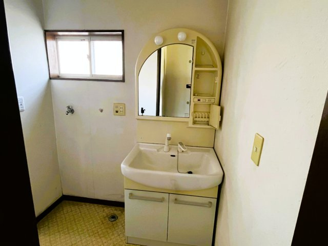 群馬県佐波郡玉村町飯塚　中古戸建　～窓から緑豊かな田園風景を望む、平坦で穏やかな住環境。～の洗面所|小窓から光が差し込む洗面室。鏡の横に収納棚が付いています。