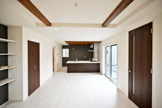 ブルーミングガーデン山本野里2丁目新築戸建て│3LDK+駐車2台可のキッチン|リビングからキッチンまで視線が通る、開放感のある室内。木目の折上天井とキッチン上部の折下げ天井が、空間にメリハリを生み出します。大きな窓から自然光が入り、明るく心地よい住まいです。