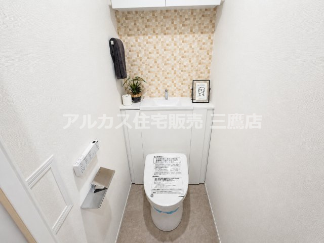 ベルジュール三鷹のトイレ|手洗いカウンターと収納を備えたトイレ。モザイク調の壁面が空間のアクセントです。