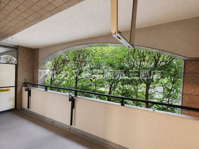 ベルジュール三鷹のバルコニー|屋根付きのバルコニー。手すり越しに植栽が見え、外とのつながりを感じられます。