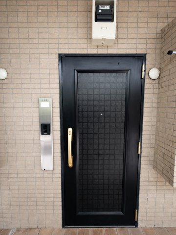 ベルジュール三鷹の玄関|格子状のデザインが印象的な住戸玄関。インターホンを備えています。