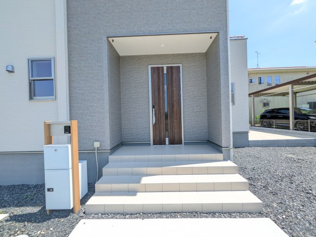 第1　常総市中妻町　新築戸建て　1号棟の玄関|お洒落な玄関ドアと洗練された外壁デザイン。家の顔にふさわしい上質な佇まいで、ご家族やお客様を迎えます。