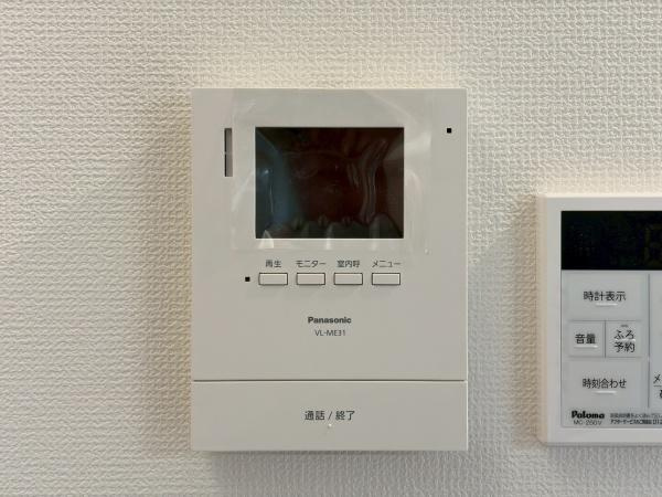 川崎市川崎区小田２丁目の新築一戸建のその他|壁に設置されたモニター付きインターホンが来訪者の確認をサポートします。大きな液晶画面で視認性も良好です。操作ボタンもシンプルで使い勝手が考慮されています。日常の安全性や安心感が感じられる設備です。