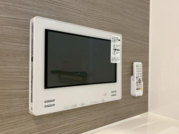 川崎市川崎区小田２丁目の新築一戸建の浴室|壁面に設置されたテレビモニターが特徴の空間です。リモコンも付属しており使い勝手に配慮されています。シンプルなデザインがインテリアになじみやすい点が魅力です。