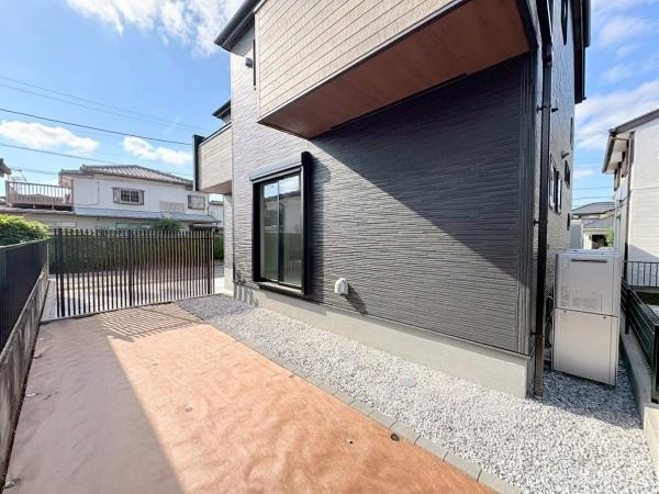 横浜市緑区いぶき野の新築一戸建の庭|庭部分は日当たりが良く開放感が広がります。フェンスで囲まれており安心してご利用いただけます。建物横のスペースはお手入れしやすい仕様です。採光も確保しやすくゆとりを感じる外構です。