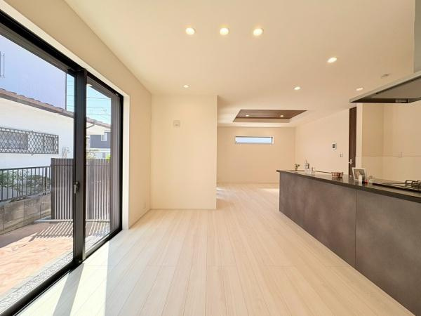 横浜市緑区いぶき野の新築一戸建の居間・リビング|リビングダイニングには広々とした空間が広がっており大きな窓から自然光がたっぷり入ります。LDKには床暖房が標準で装備されています。キッチンと一体になったレイアウトも魅力的です。
