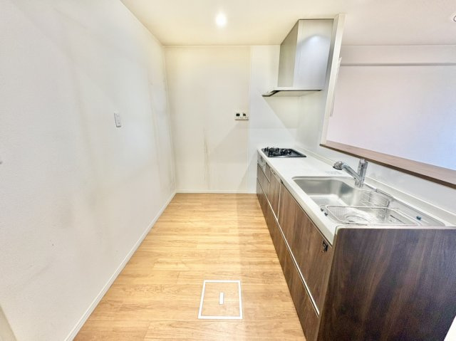 御影パークマンションのキッチン|ご夫婦や親子で並んで快適に料理ができる、ゆとりある通路幅を確保したキッチンスペース。背面には冷蔵庫やカップボードも配置しやすく、調理から配膳、片付けまでの日々の家事動線がスムーズにこなせる設計です。
