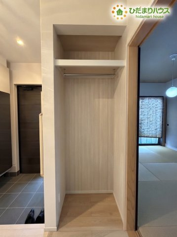 熊谷市野原　中古一戸建ての収納|※AIにて残置物加工
ハンガーパイプと上部棚が備えられた、使い勝手の良い便利な収納スペースです！お出かけ用のコートやジャケットをすっきりと掛けて収納でき、帰宅後すぐに衣類を片付けられるスムーズな動線♪