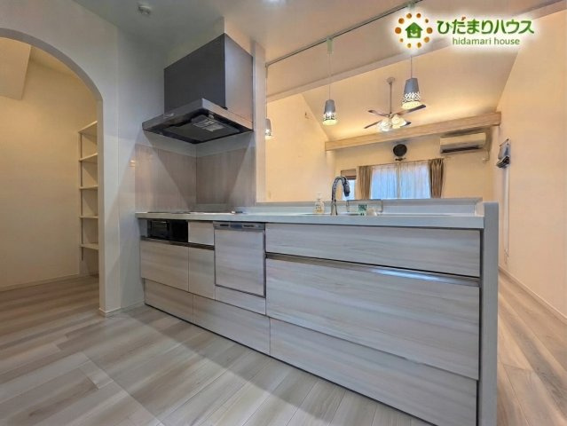 熊谷市野原　中古一戸建てのキッチン|※AIにて残置物加工
すっきりと美しい木目調デザインのシステムキッチンです！リビング全体を見渡せる開放的な配置で、お料理中もご家族との会話を楽しく弾ませることができます♪