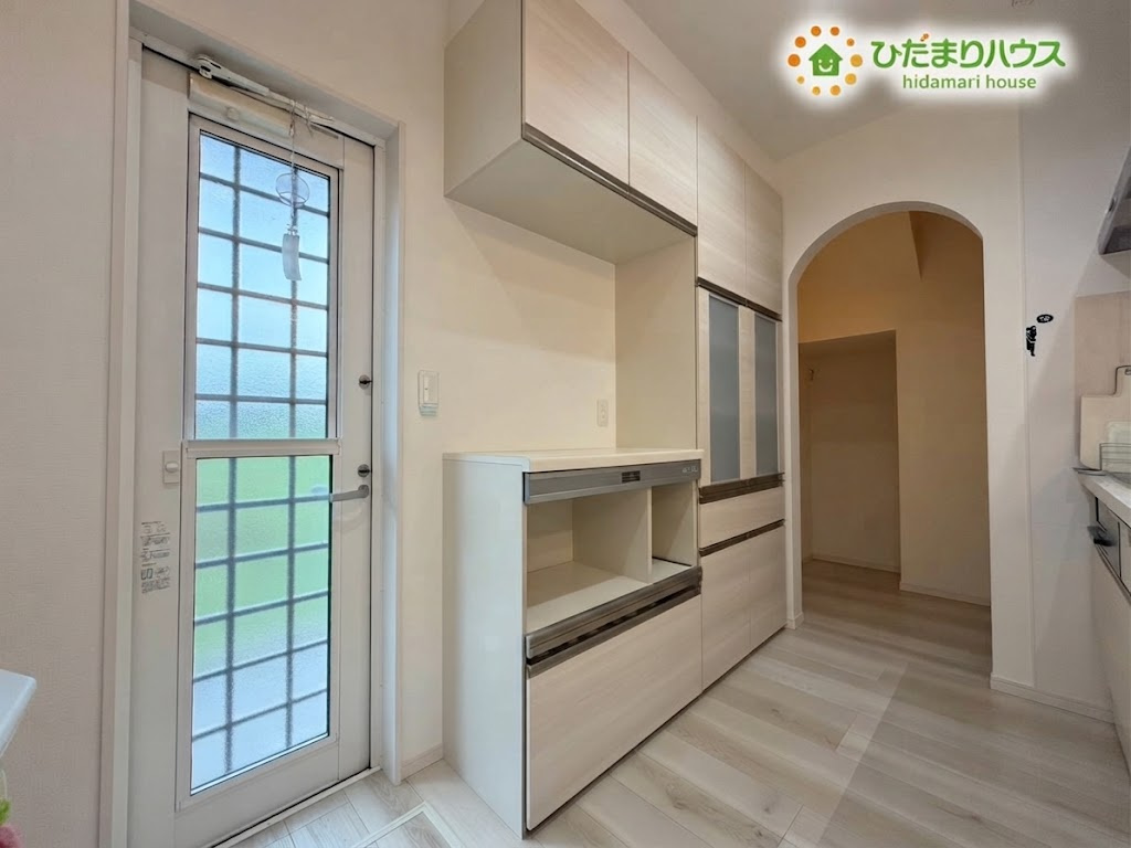 熊谷市野原　中古一戸建ての収納|※AIにて残置物加工
収納力が高いのカップボードが備えられた、すっきりと片付くキッチンです！勝手口からの爽やかな光や風が心地よく、毎日の家事も快適に楽しくこなせます♪