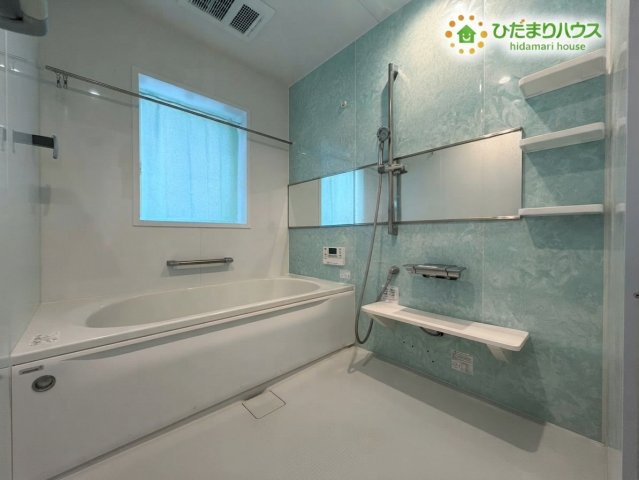 熊谷市野原　中古一戸建ての浴室|※AIにて残置物加工
ゆったりとした1.25坪サイズの広々としたバスルームです！爽やかなアクセントパネルが癒やしの空間を演出し、足を伸ばして一日の疲れをしっかりと癒やせます♪